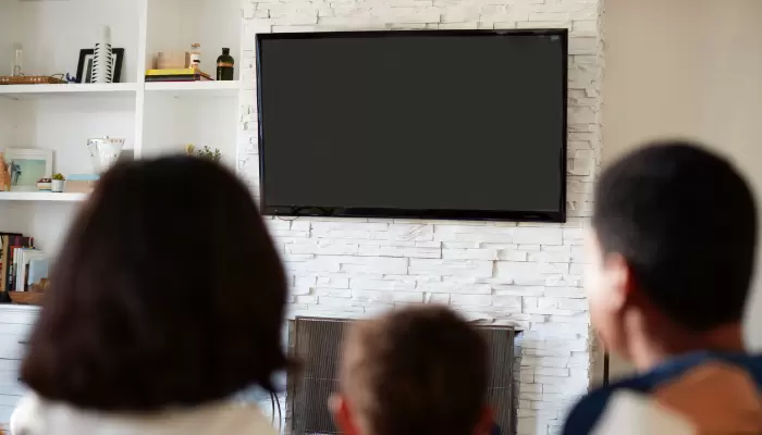 Family looking at tv mounted on wall