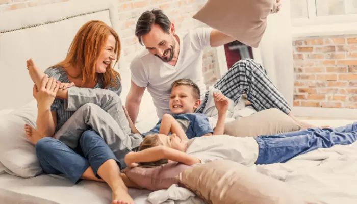 Happy family playing in bed